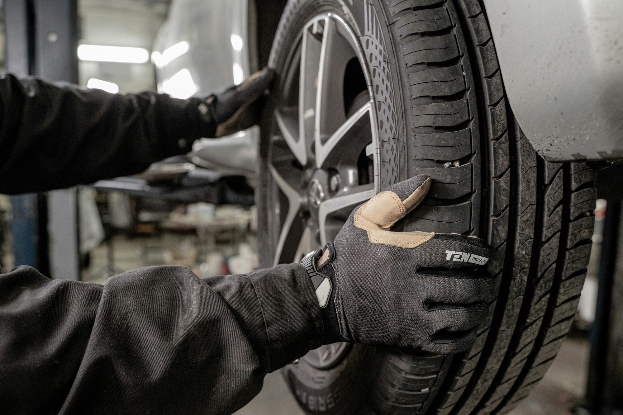 Mecânico com luva ajustando a roda de um carro